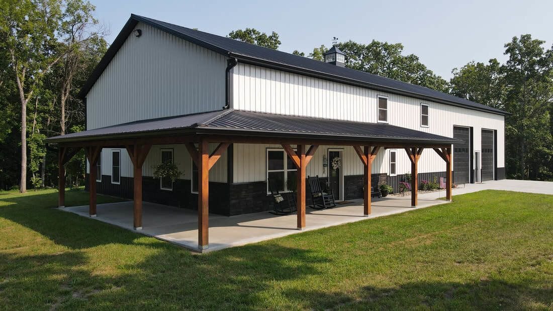 White steel shop with black roof, stone wainscot and timber-post covered porch